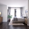 Large well lit bed room with wood floors and large windows 